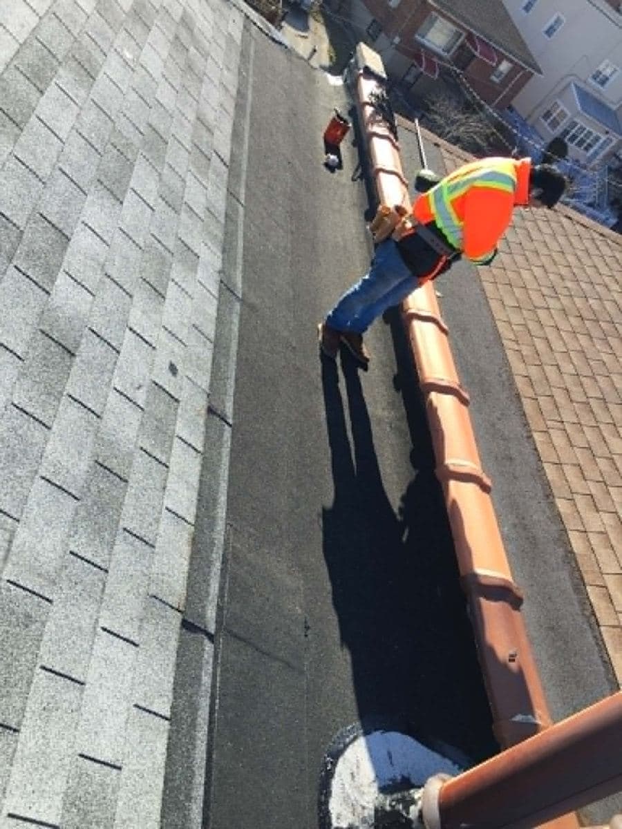 Roofer working along the edge of a shingle roof