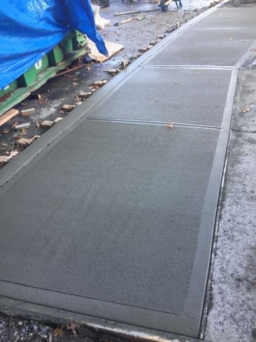 New concrete sidewalk section poured between existing edges