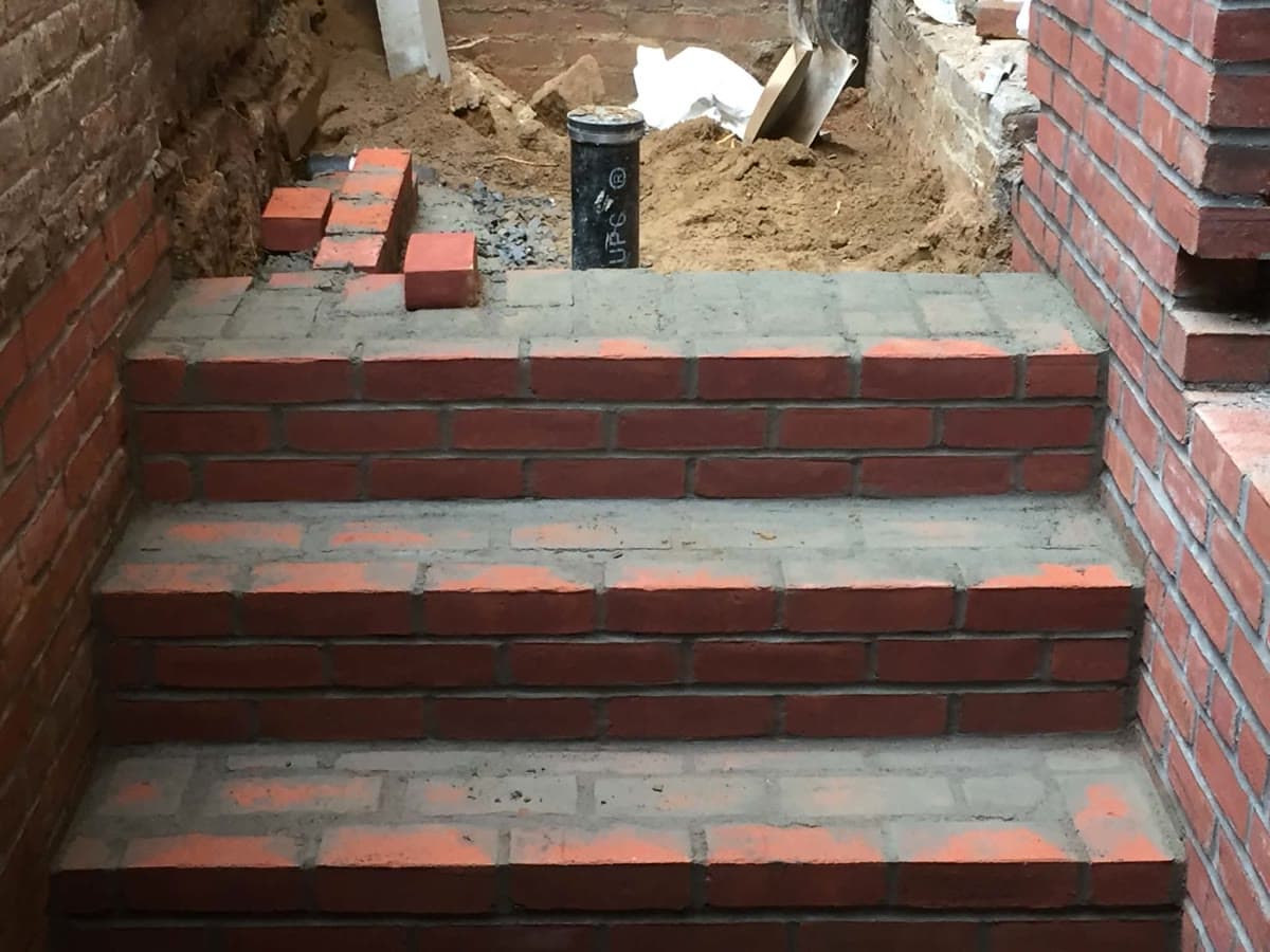 Brick masonry steps with dark treads between exterior walls