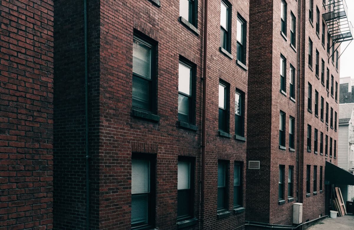 Illustrative tall red brick apartment building with masonry walls