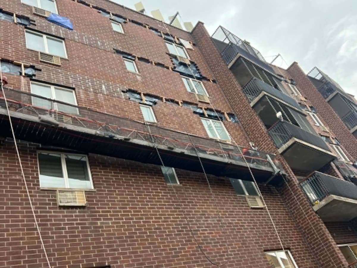 Brick apartment facade undergoing exterior masonry repair