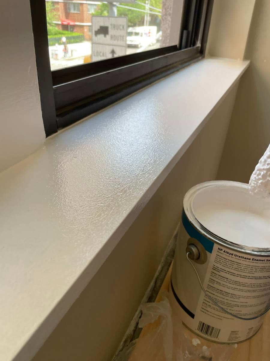 Close view of freshly painted interior trim and wall beside a window