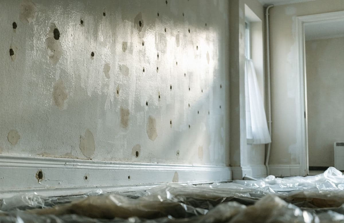 Illustrative interior wall with patched holes and spackle before painting