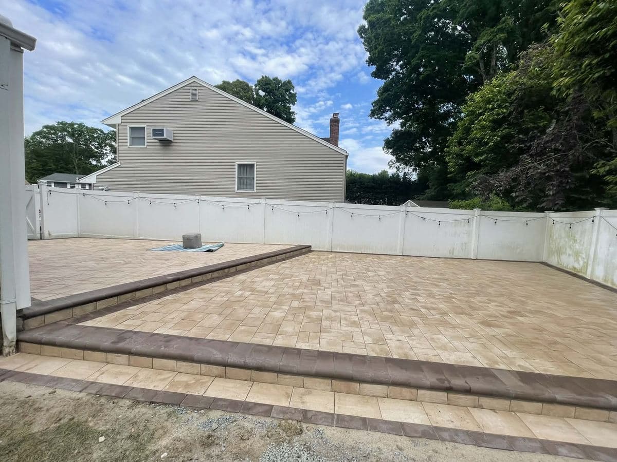 Paver patio with a stepped border managing the yard's grade change