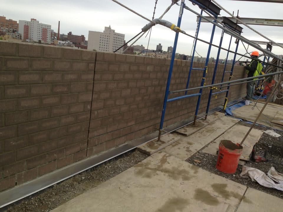 Long block wall with scaffolding set up for joint work