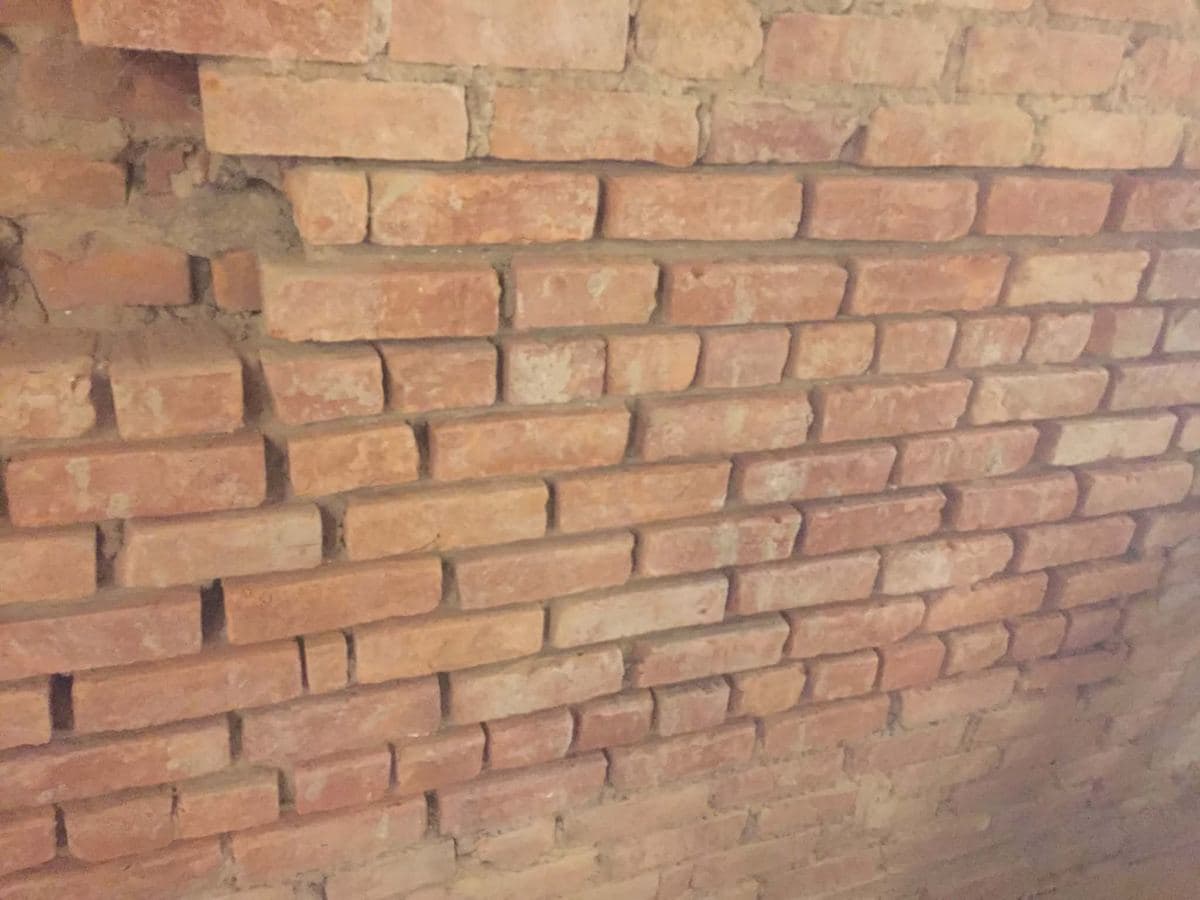 Older brick wall with eroded, sandy mortar joints