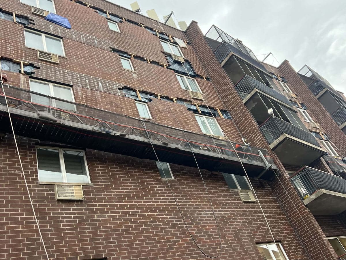 Apartment building facade prepared for exterior masonry joint work