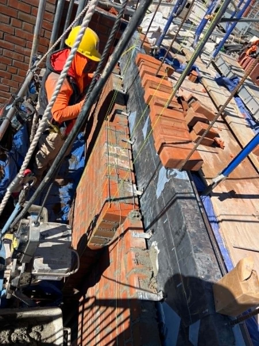 Crew working along a brick facade from a supported access platform