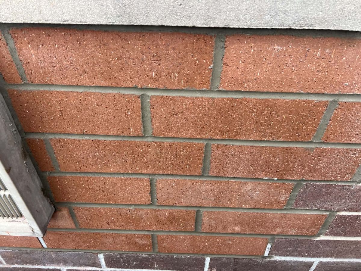 Repointed brick joints beside a window opening
