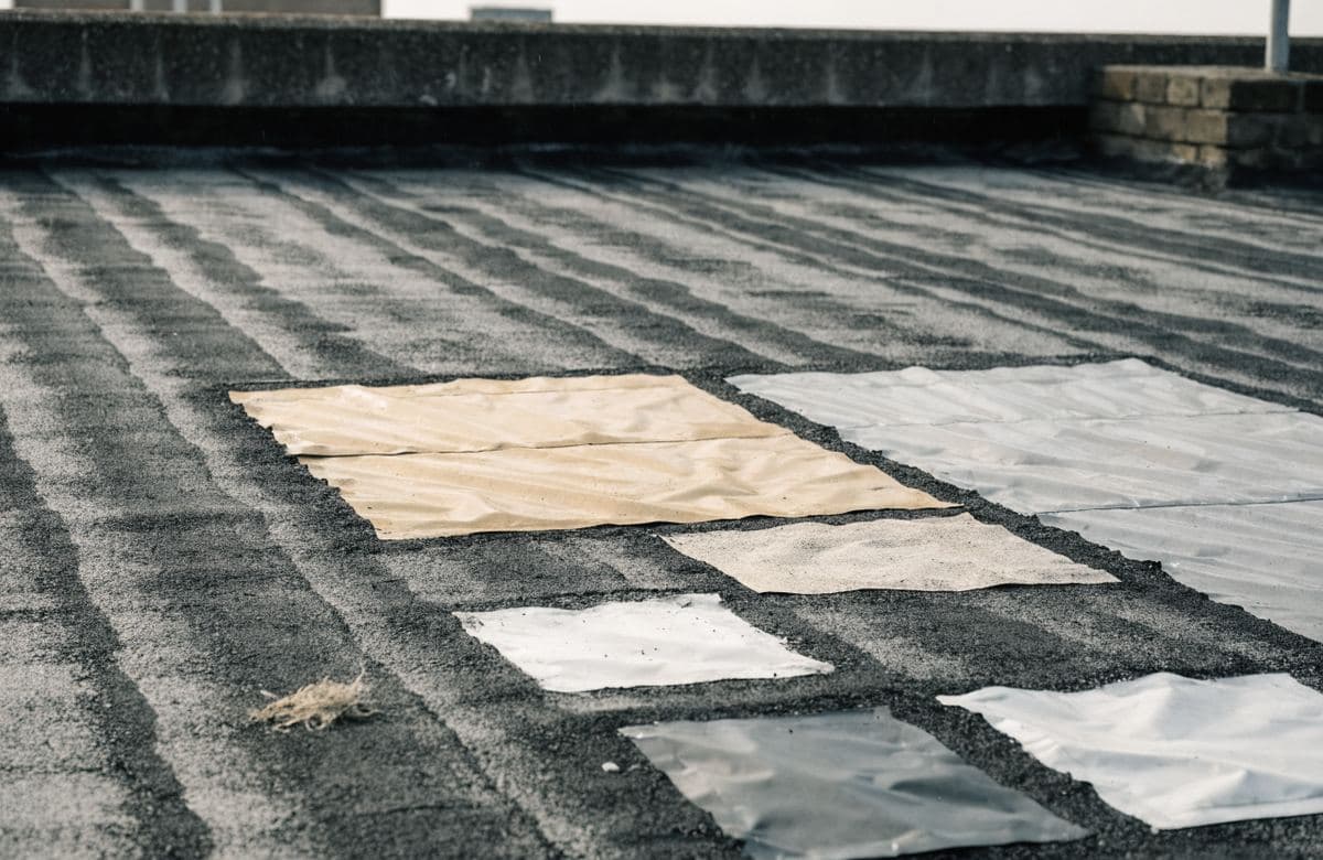 Illustrative flat roof with several mismatched patch repairs